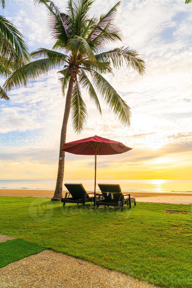 parapluie avec chaise avec fond de plage de mer et lever de soleil le matin photo