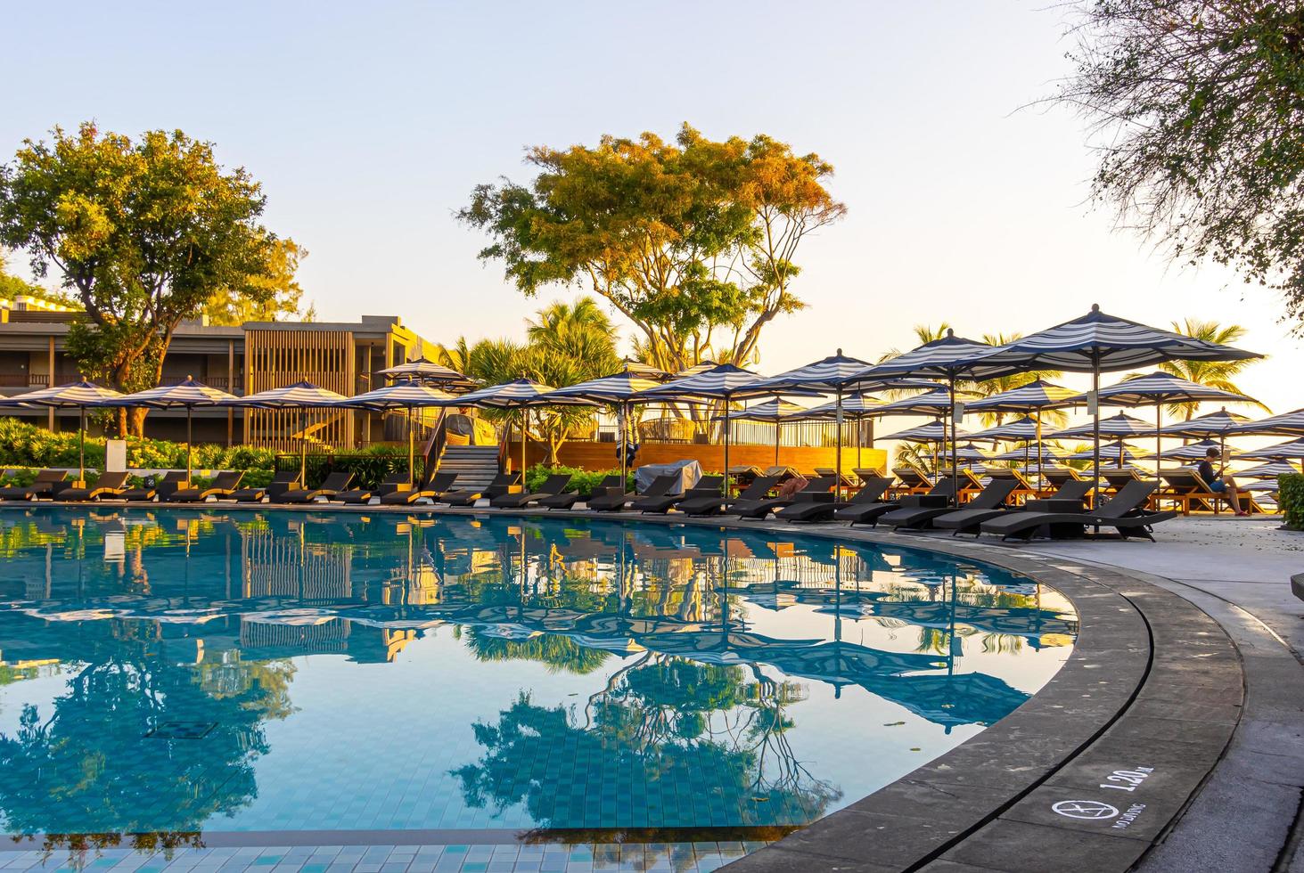 Parasol et lit de piscine autour d'une piscine extérieure dans un complexe hôtelier pour des vacances en voyage photo
