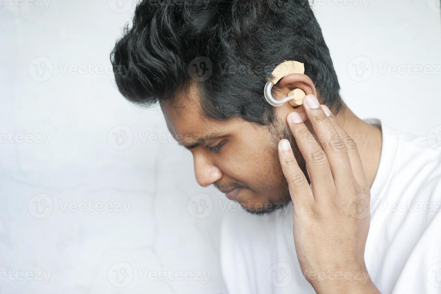 concept d'aide auditive, un jeune homme ayant des problèmes d'audition photo