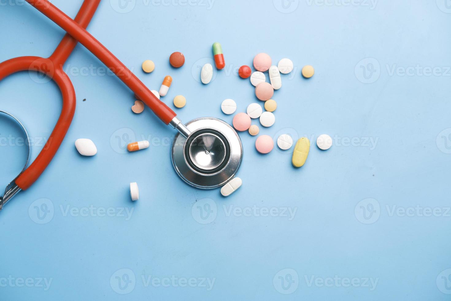 Pilules médicales colorées et stéthoscope sur fond bleu photo