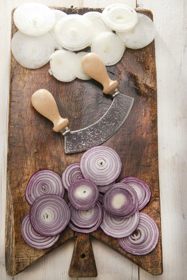 une couteau et une bouquet de oignons sur une Coupe planche photo