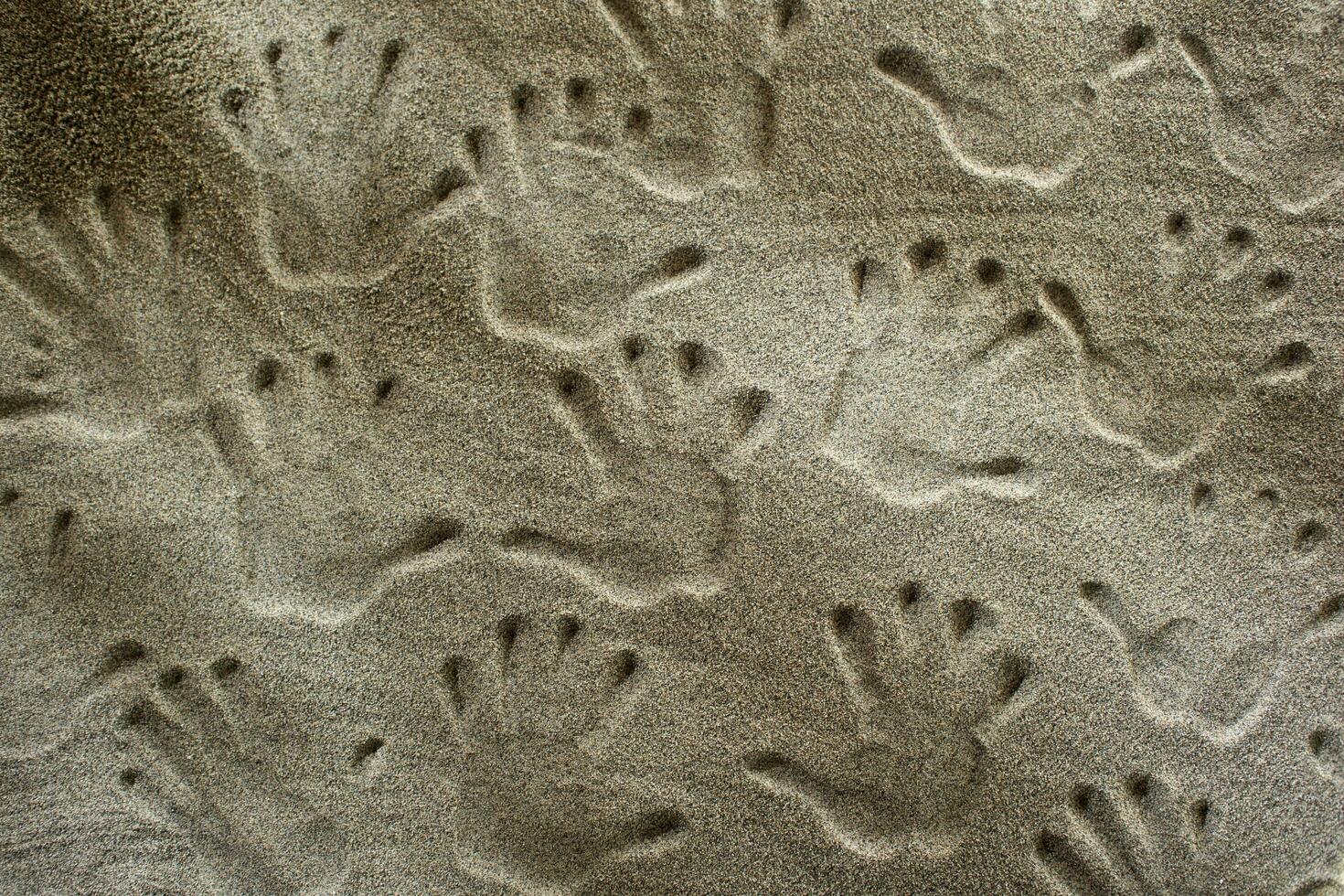 empreintes de mains dans le le sable photo