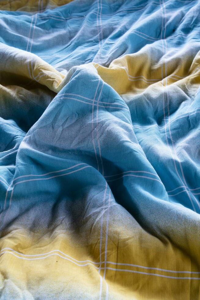 coloré couverture dans un défait lit et pâturage lumière photo