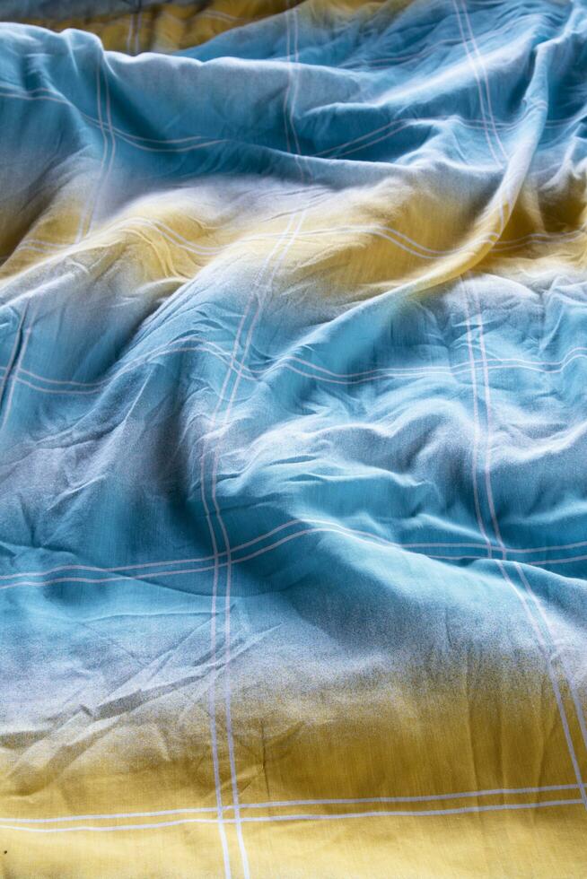 coloré couverture dans un défait lit et pâturage lumière photo