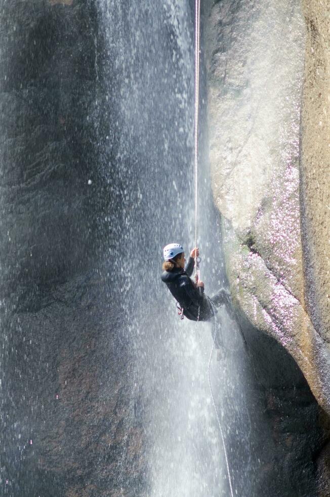 une la personne sur une corde escalade en haut une cascade photo