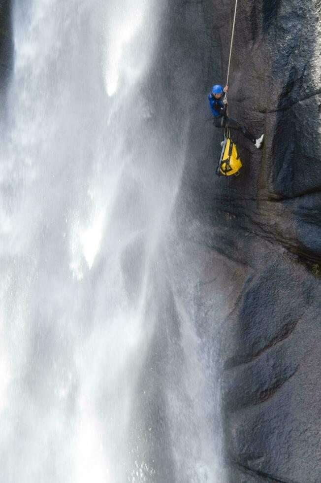 une la personne sur une corde escalade en haut une cascade photo