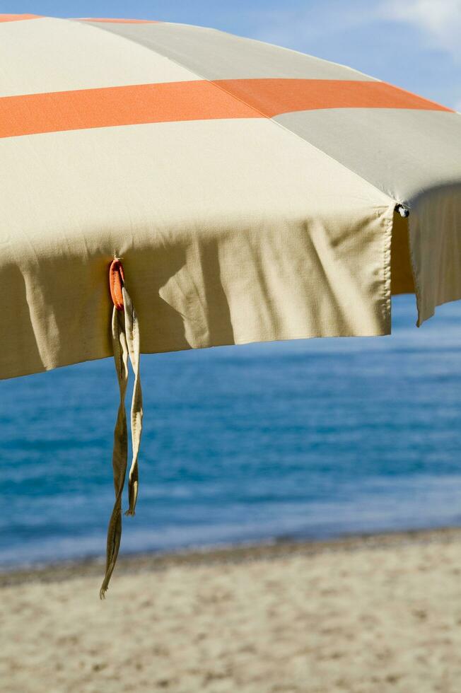 une plage parapluie avec une rayé couverture photo