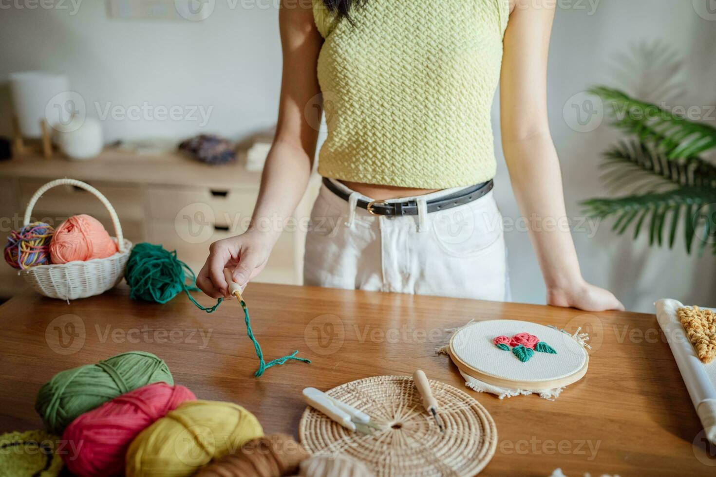 coup de poing aiguille. asiatique femme fabrication Fait main loisir tricot dans studio atelier. designer lieu de travail Fait main artisanat projet DIY broderie concept. photo