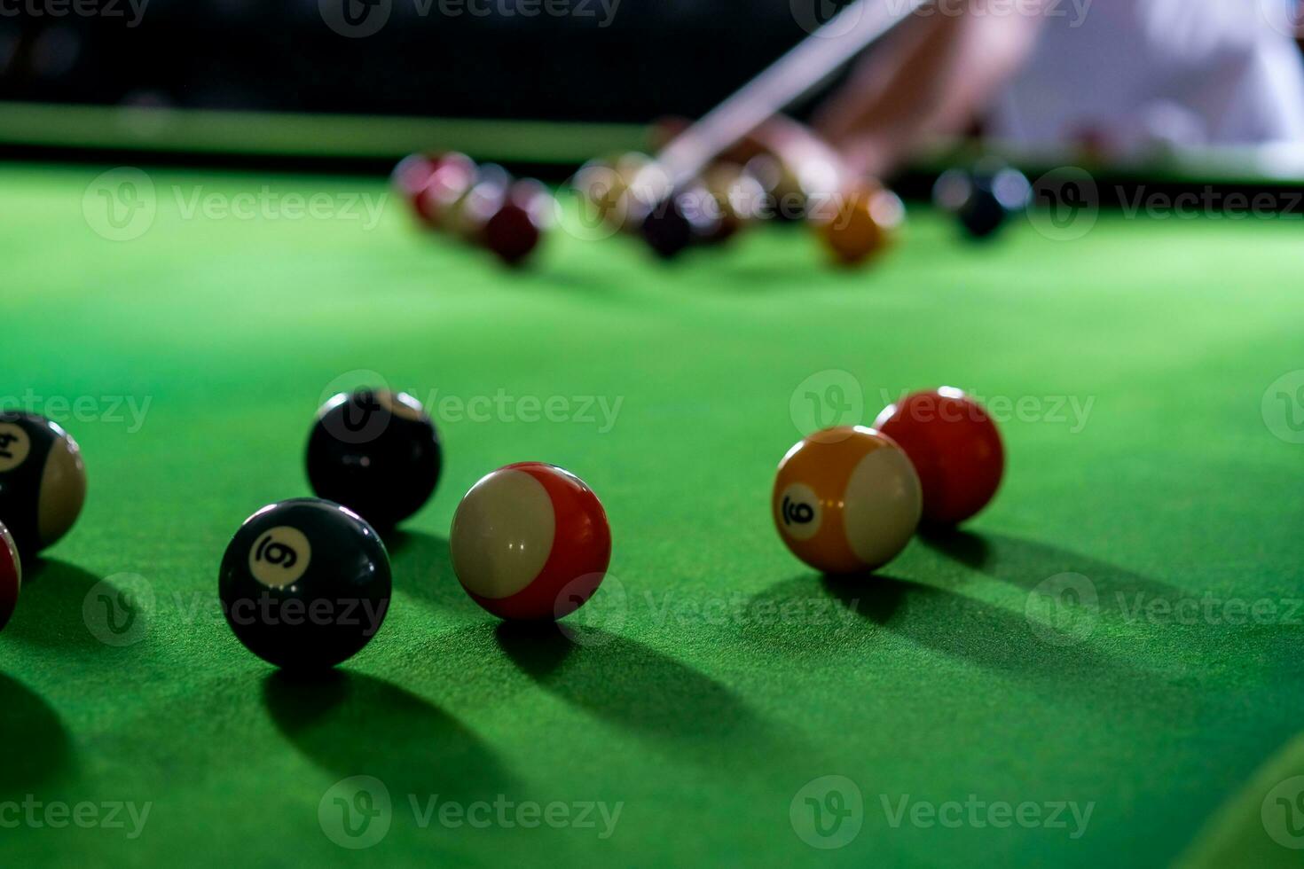 homme main et queue bras en jouant billard Jeu ou en train de préparer visée à tirer bassin des balles sur une vert billard tableau. coloré billard des balles sur vert frise. photo