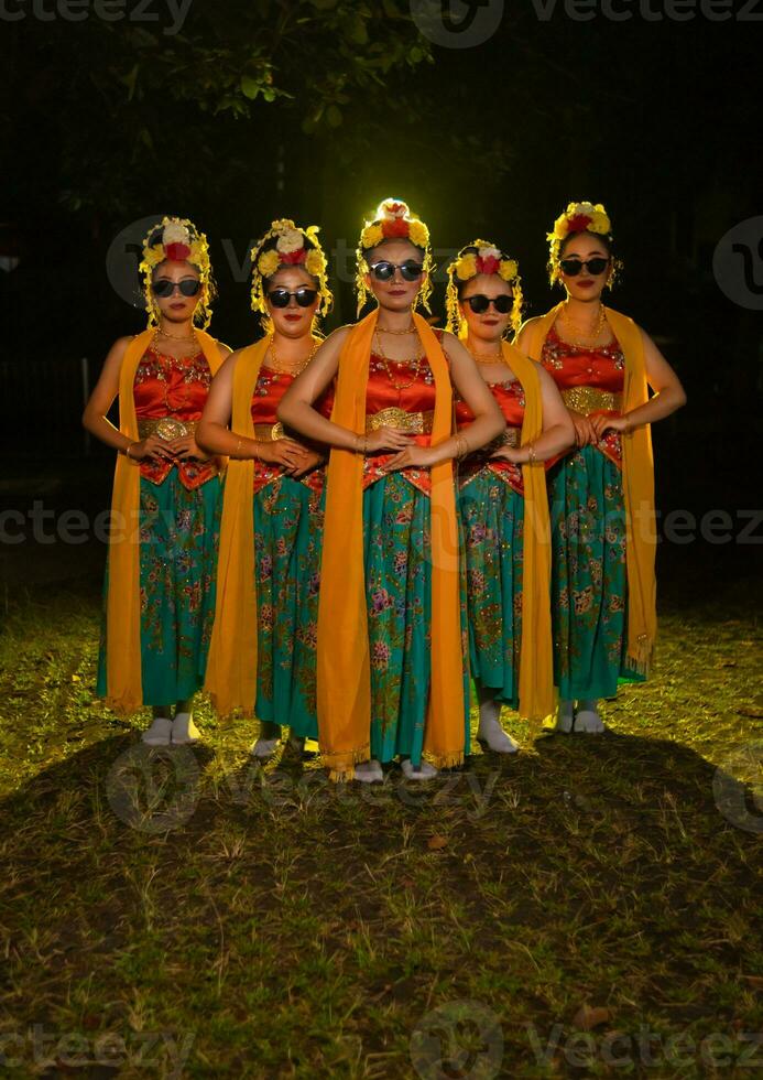 une groupe de indonésien traditionnel danseurs Danse avec leur copains dans de face de le étape lumières photo