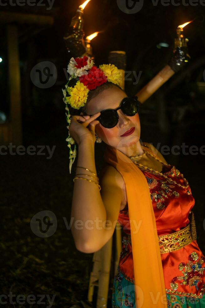 une traditionnel asiatique Danseur pose avec des lunettes de soleil tandis que dansant sur étape photo