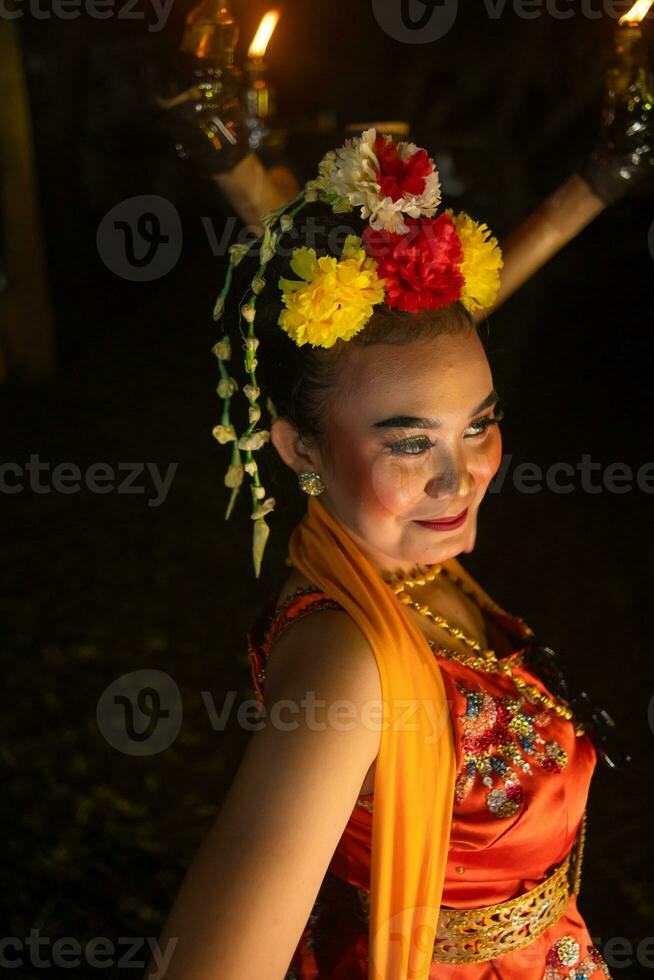 portrait de une Javanais Danseur avec fleurs sur sa tête et maquillage sur sa magnifique visage photo