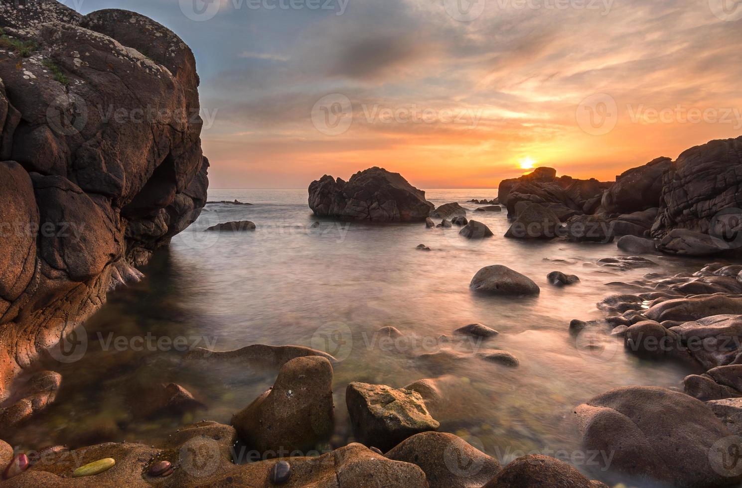 plage rocheuse au coucher du soleil photo