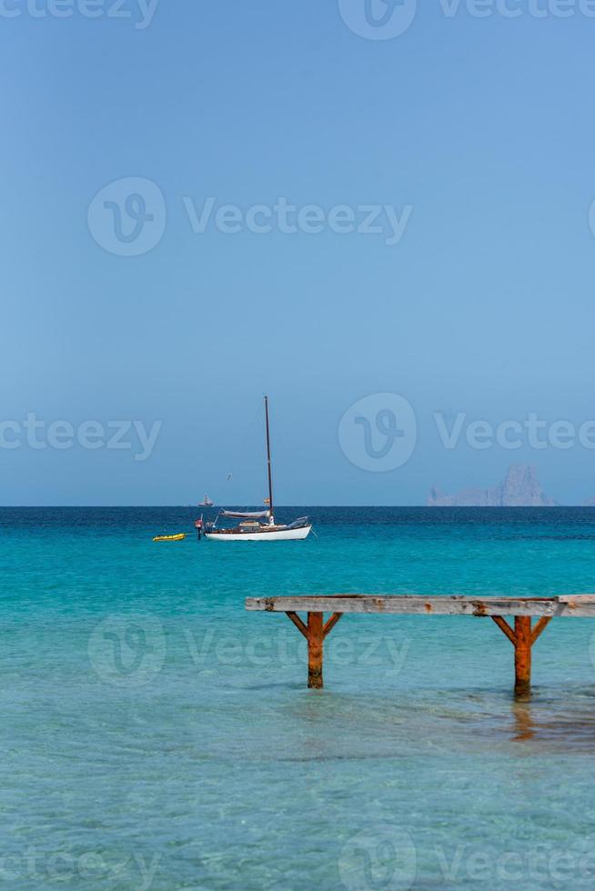 bateaux amarrés sur la côte de la plage de ses illetes à formentera, îles baléares en espagne. photo