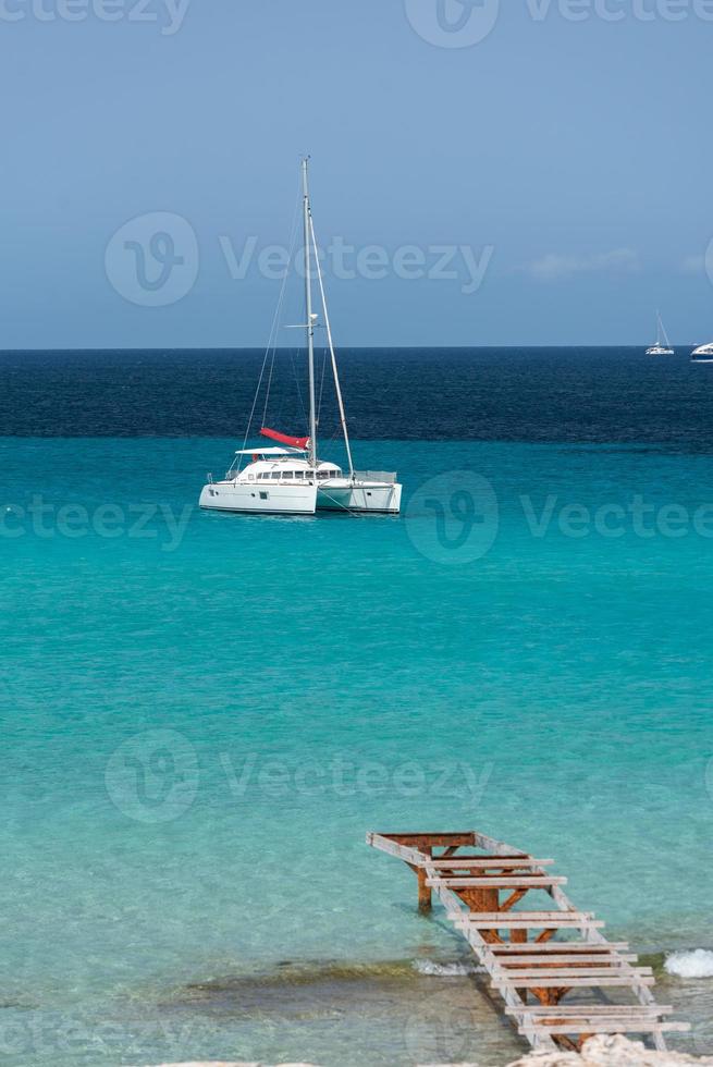 bateaux amarrés sur la côte de la plage de ses illetes à formentera, îles baléares en espagne. photo
