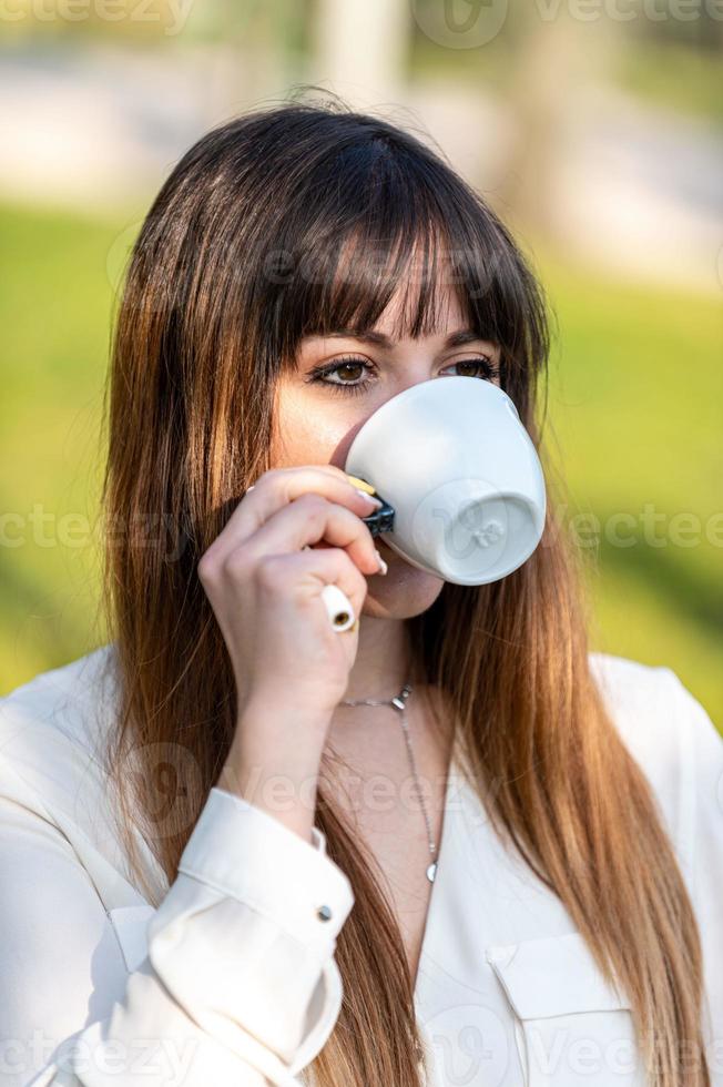 fille buvant une tasse de thé dans le jardin photo