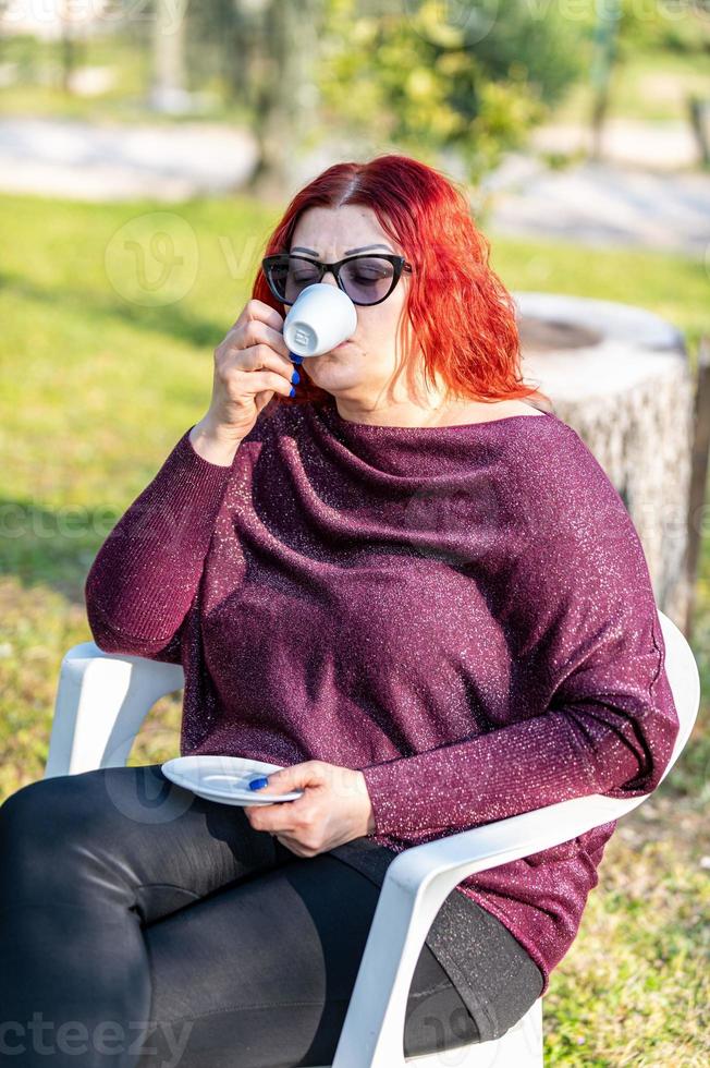 fille buvant du café dans le jardin photo