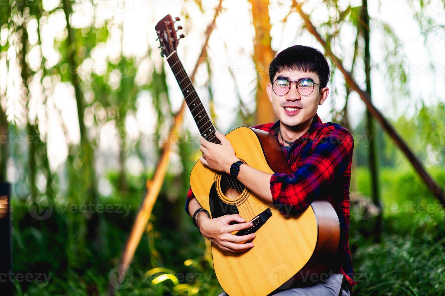 homme tenant une guitare à l'extérieur photo