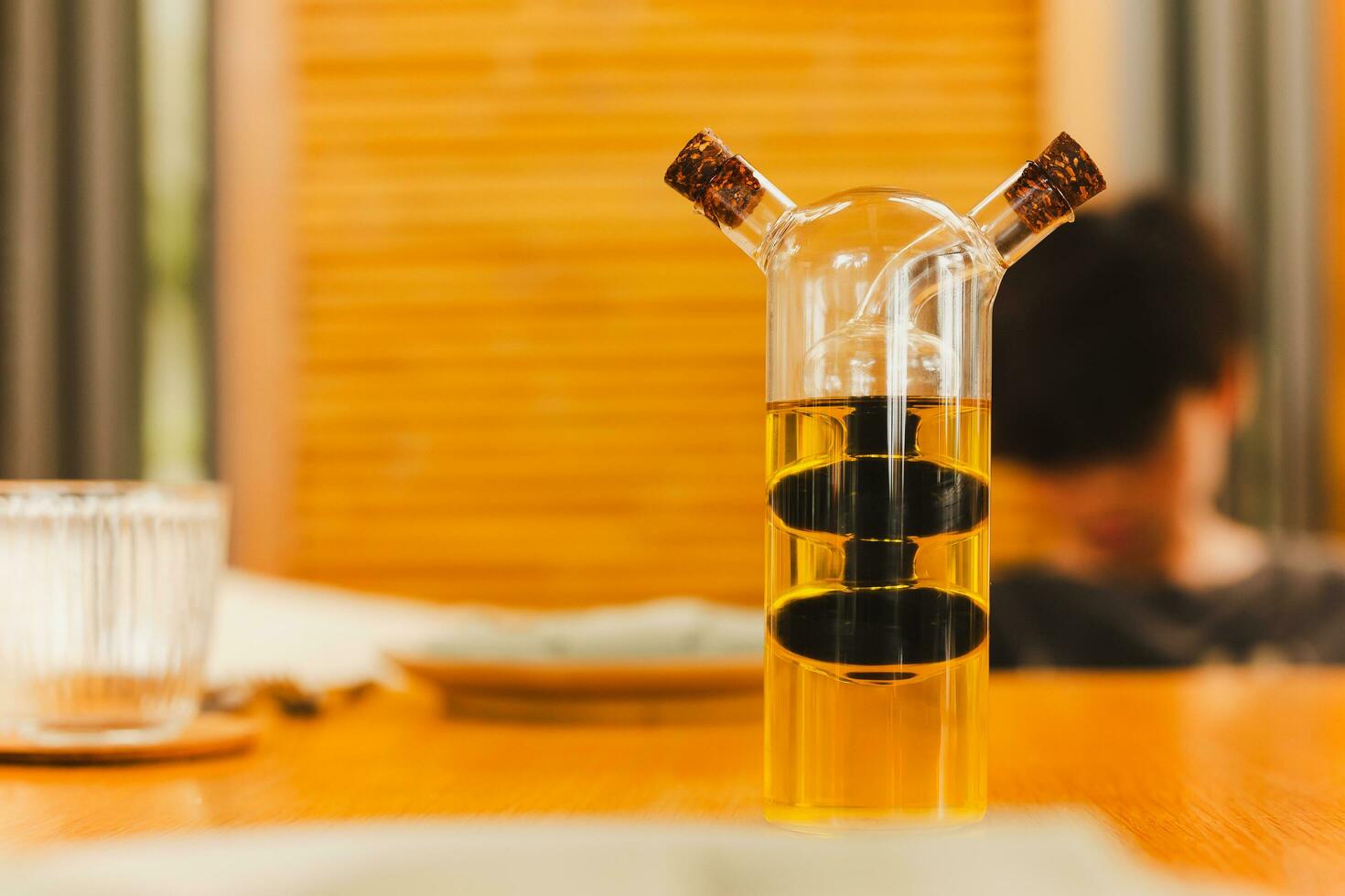 une verre bouteille avec olive pétrole et balsamique le vinaigre sur dîner tableau. photo