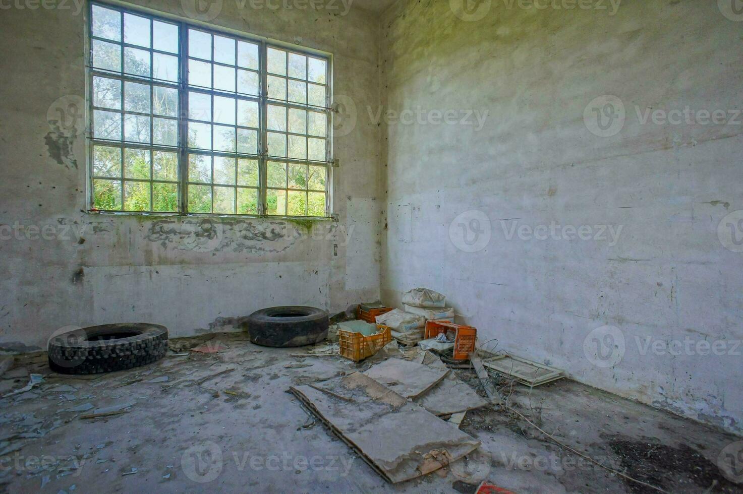 un abandonné pièce avec une fenêtre et pneus photo