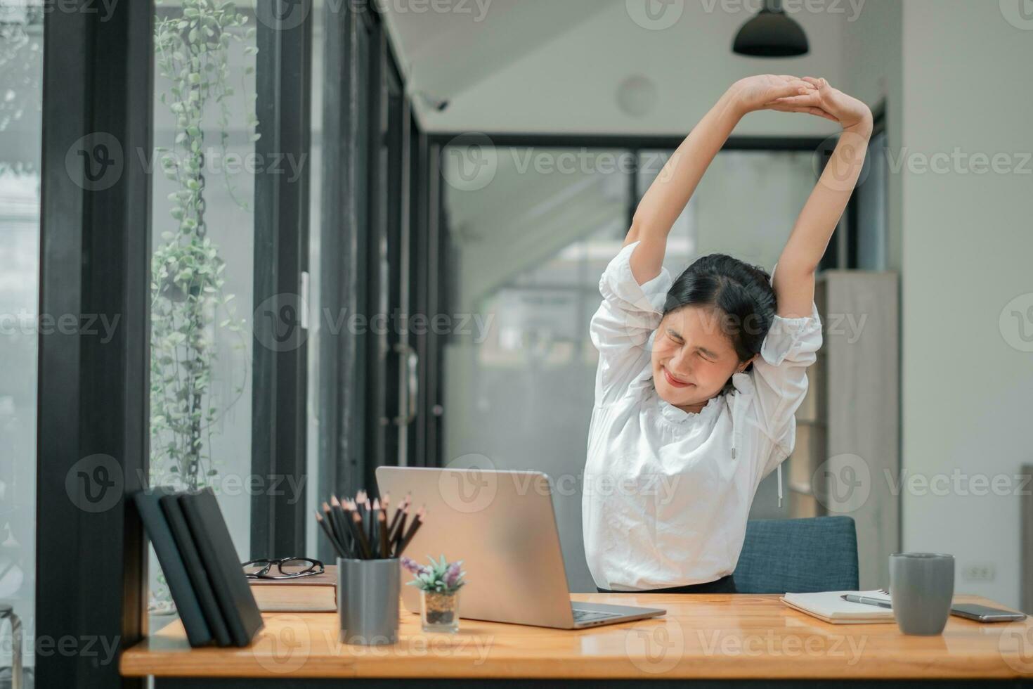 affaires femme relaxant avec mains derrière sa tête et séance sur un Bureau chaise photo