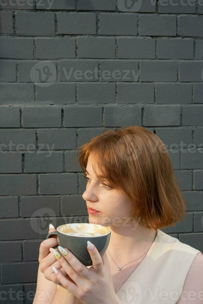 magnifique Jeune femme avec taches de rousseur les boissons café latté photo