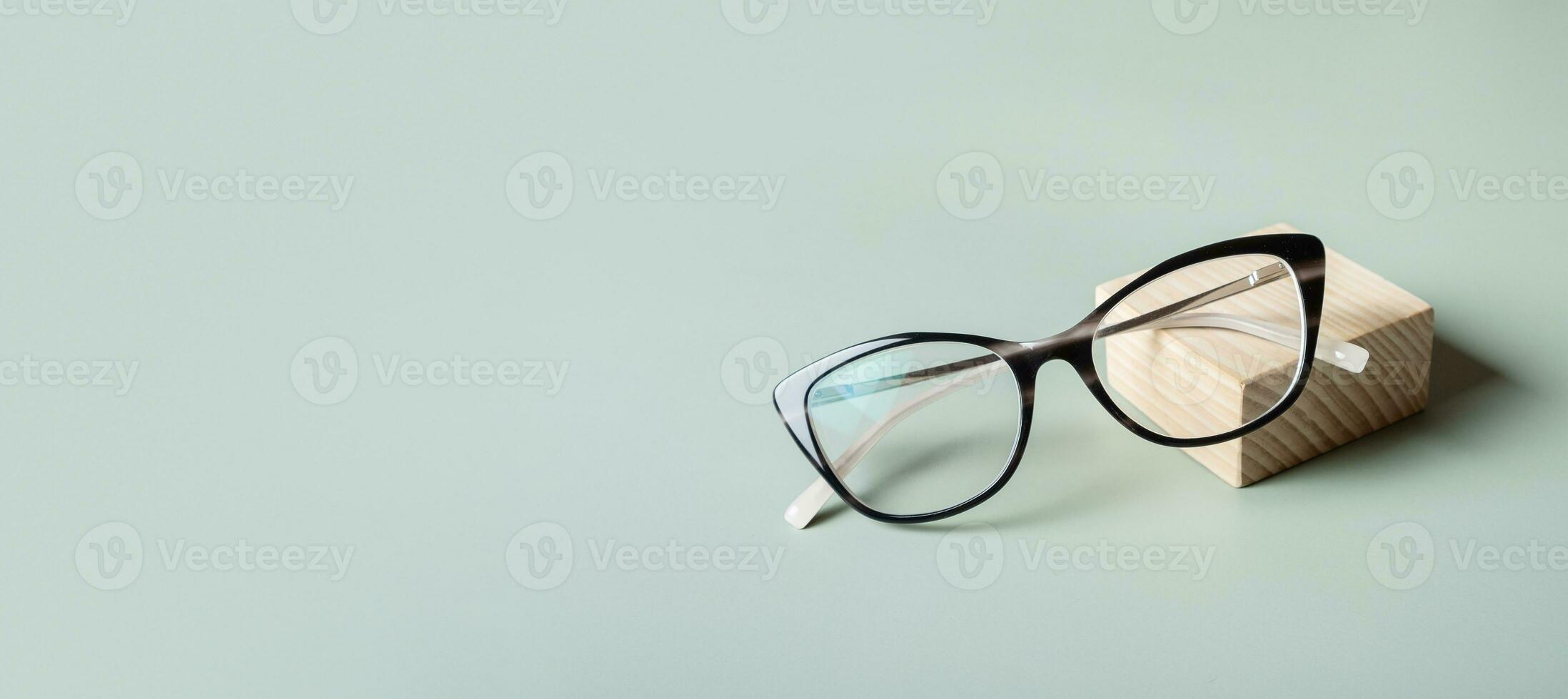 podium avec lunettes sur pastel vert bannière Contexte avec copie espace. optique magasin, vision test, élégant des lunettes concept. photo