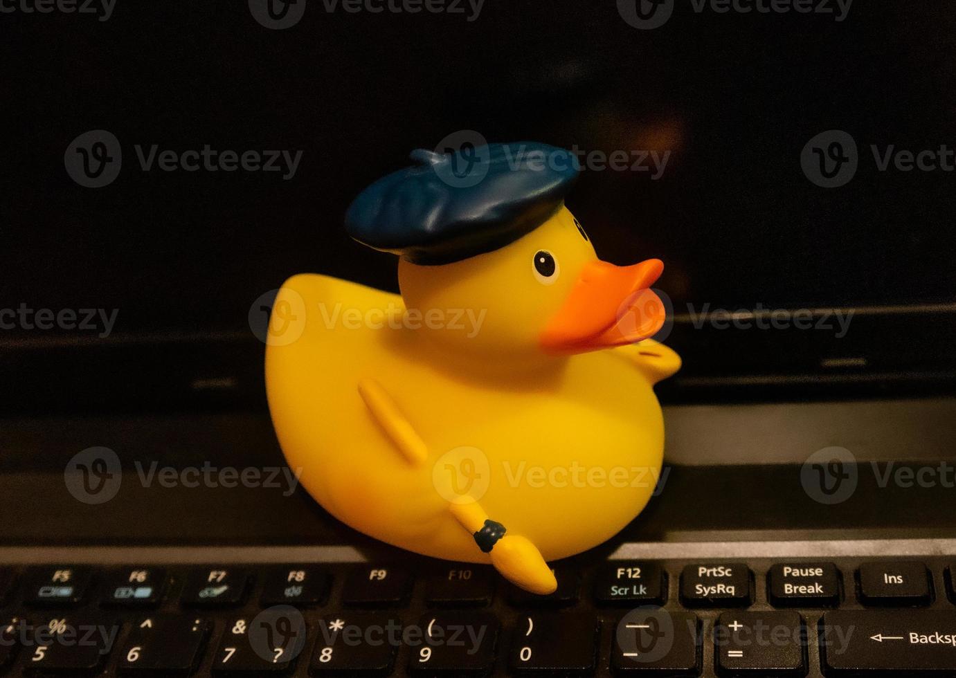 canard en caoutchouc jaune sur le clavier de l'ordinateur portable. photo