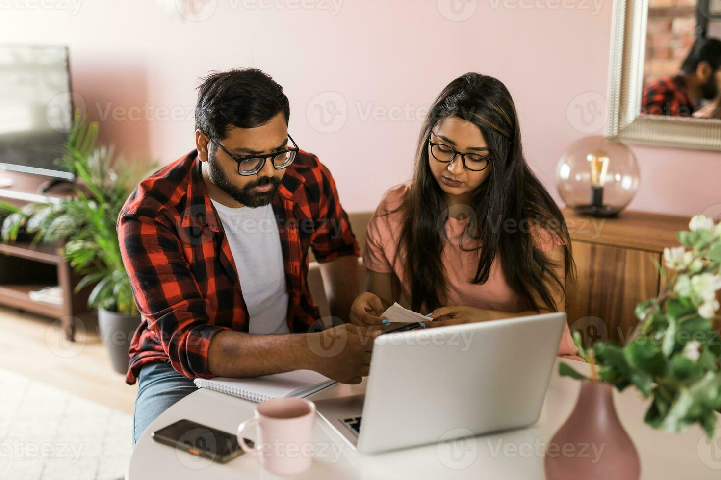 millénaire Indien mari et épouse Faire national formalités administratives, comptabilité emploi et révision papier factures, Reçus à portable ordinateur, en utilisant en ligne calculatrice - économique crise concept photo