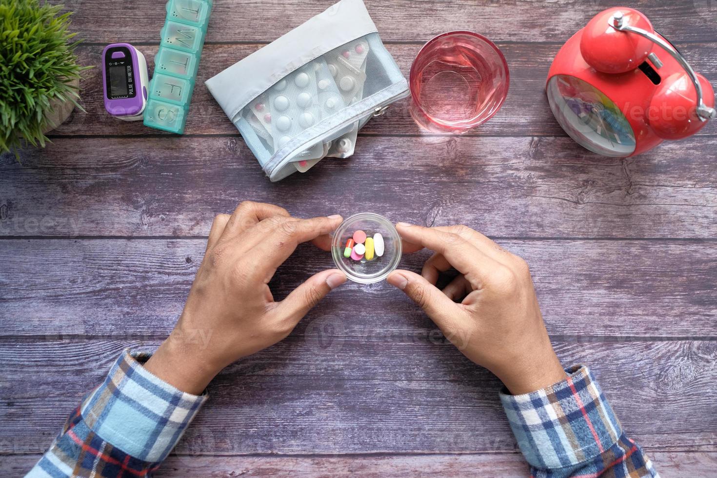 vue de dessus de la main de l'homme prenant des médicaments sur la table photo