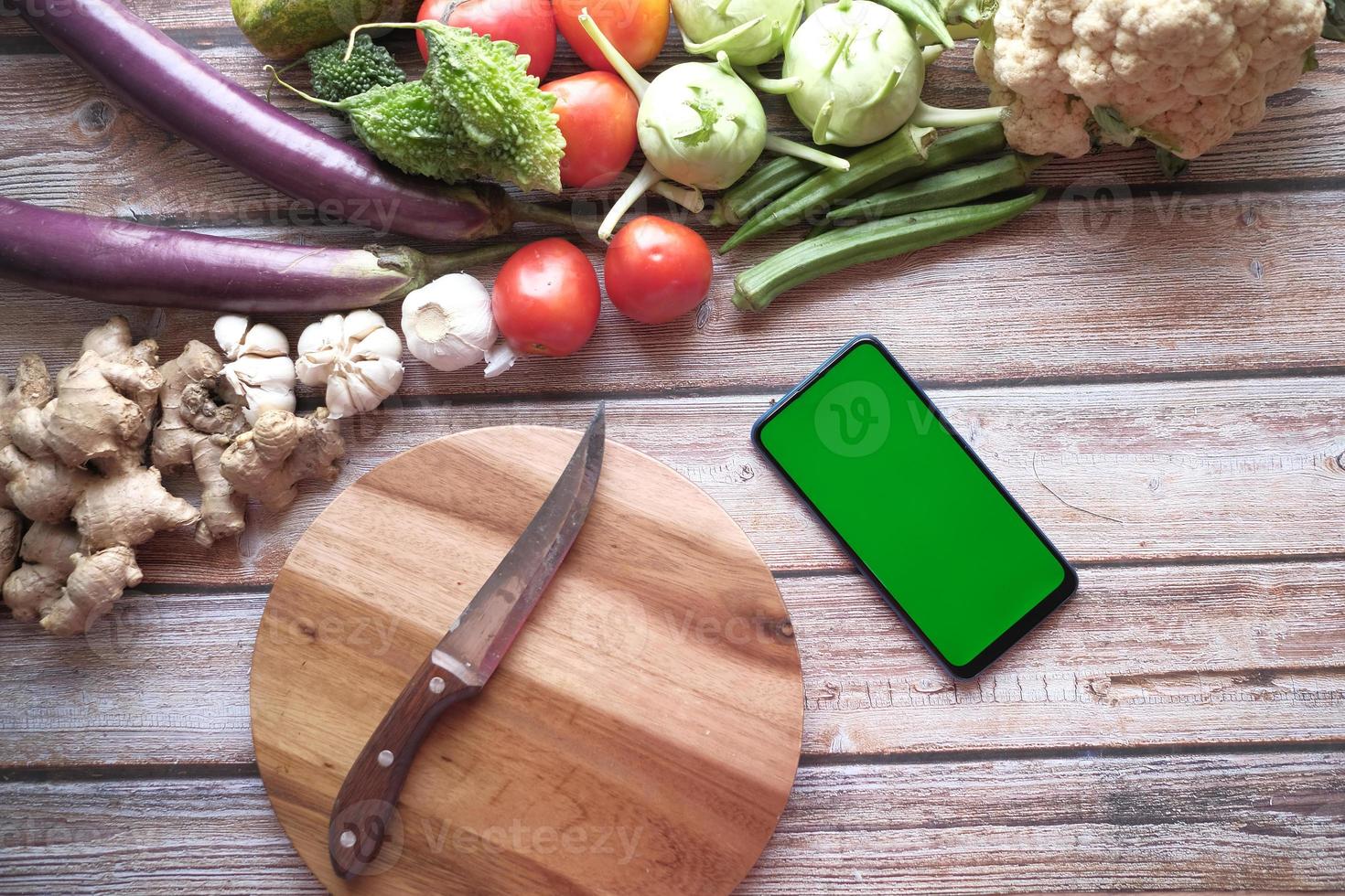 légumes frais, planche à découper et téléphone intelligent sur table photo