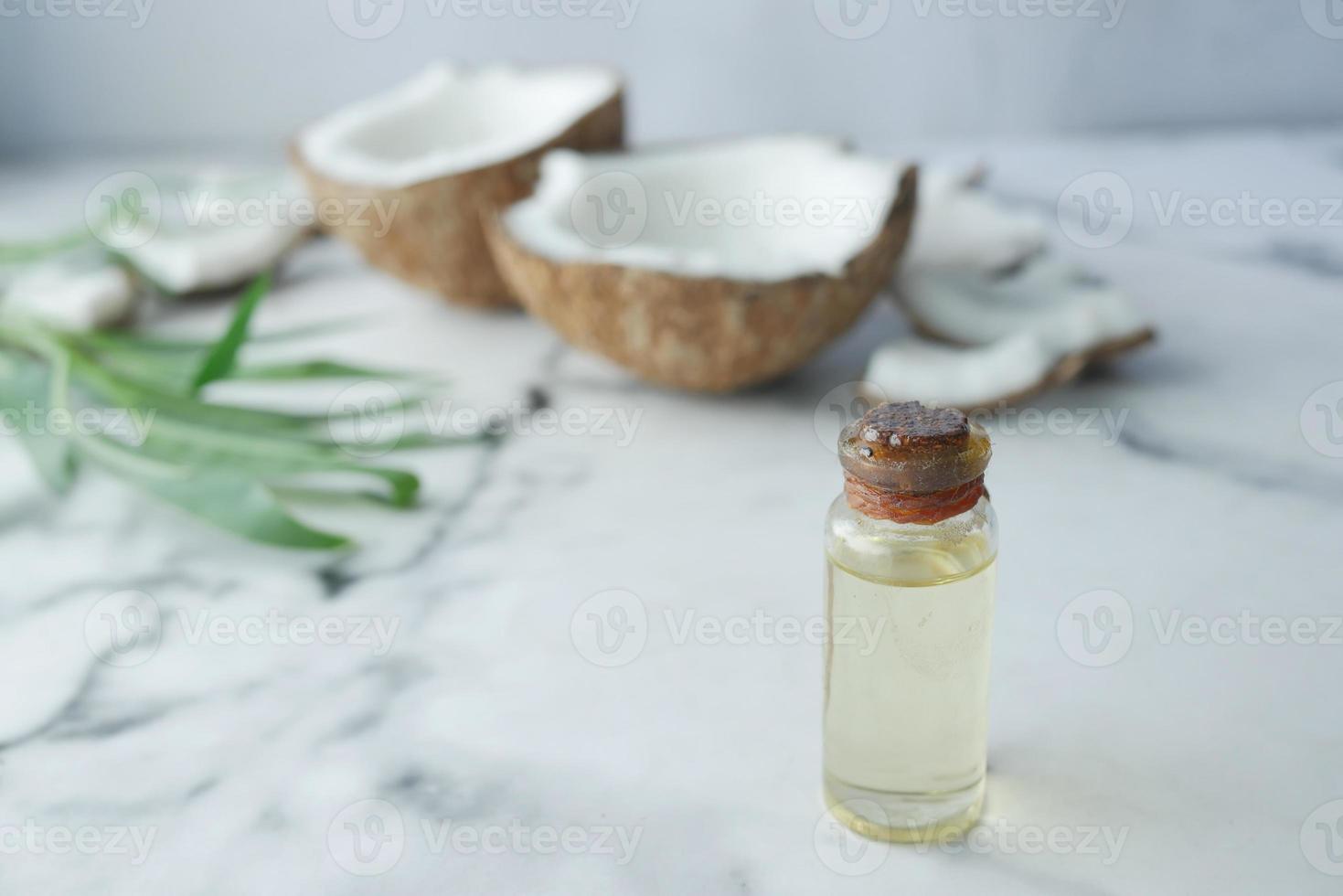 tranche de noix de coco fraîche et bouteille d'huile sur une table photo