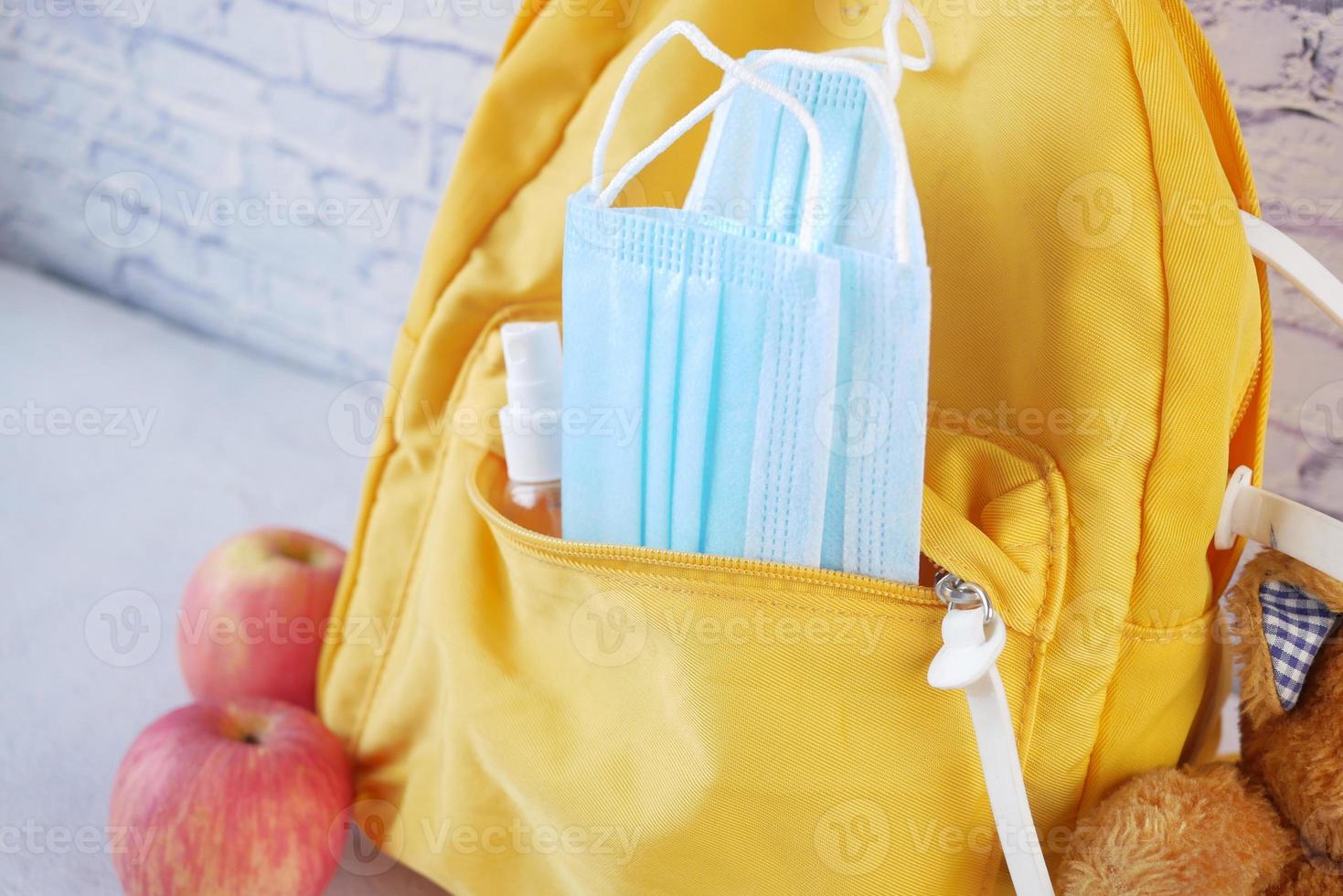 sac d'école étudiant avec désinfectant, un masque facial. photo