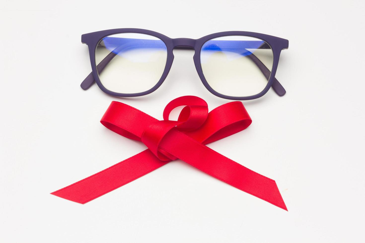 lunettes en plastique noir avec un noeud rouge photo