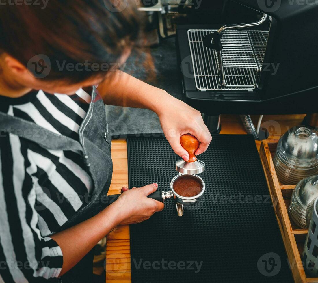 barista en portant porte-filtre et café altérer fabrication un Expresso café dans café photo