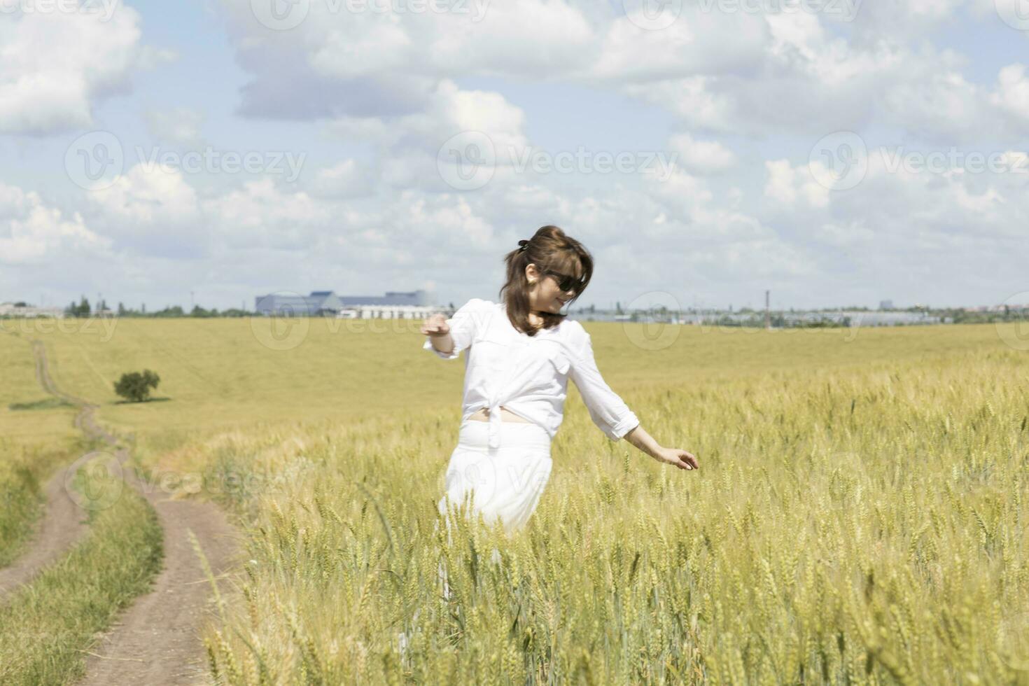 une femme dans une blanc robe permanent dans une champ photo