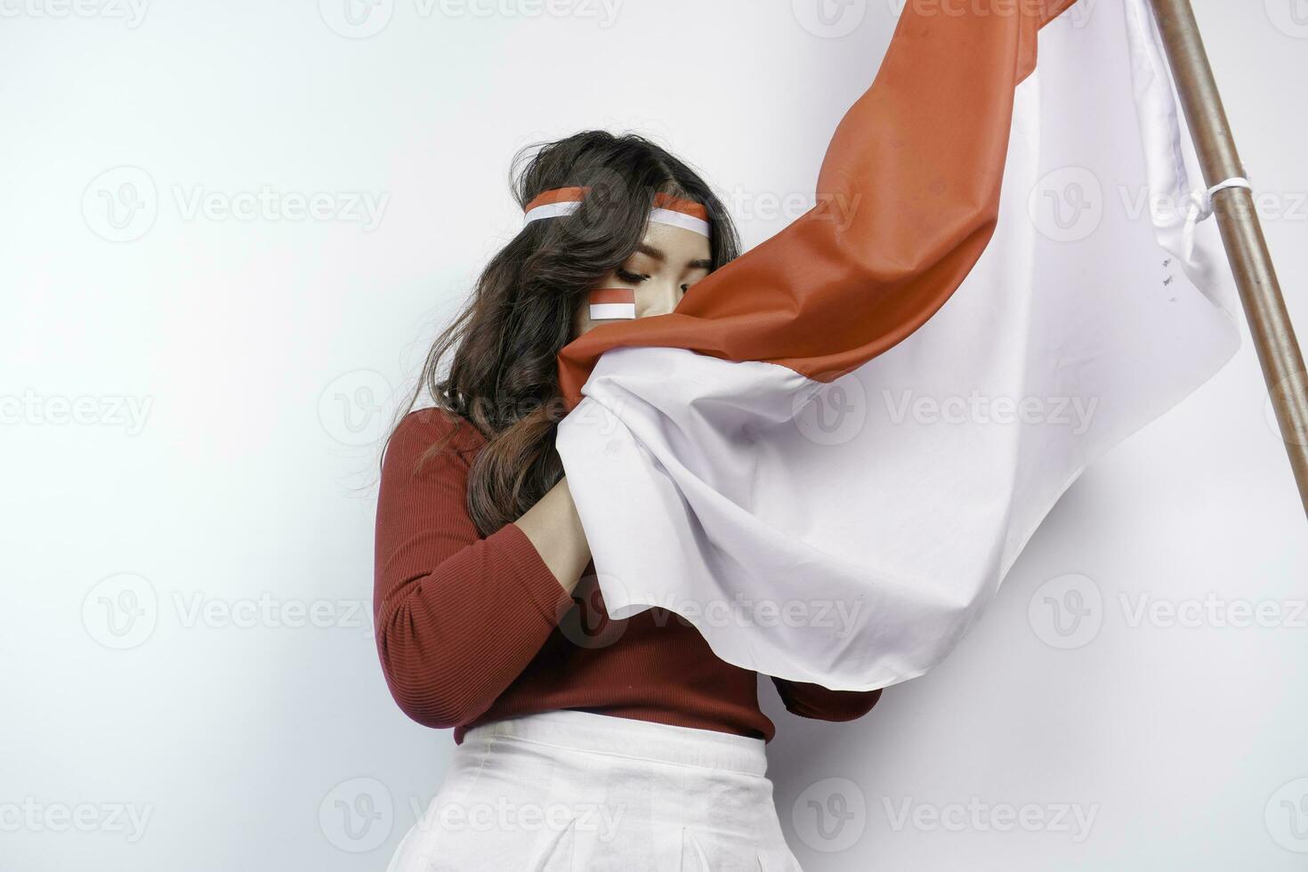 indonésien femme donner saluer avec fier geste tandis que en portant l'indonésie drapeau. l'indonésie indépendance journée concept. photo