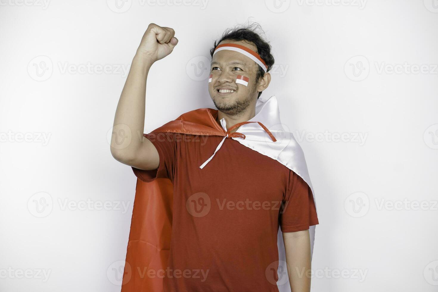 une Jeune asiatique homme avec une content réussi expression portant rouge Haut et Bandeau tandis que en portant l'indonésie drapeau, isolé par blanc Contexte. l'indonésie indépendance journée concept. photo