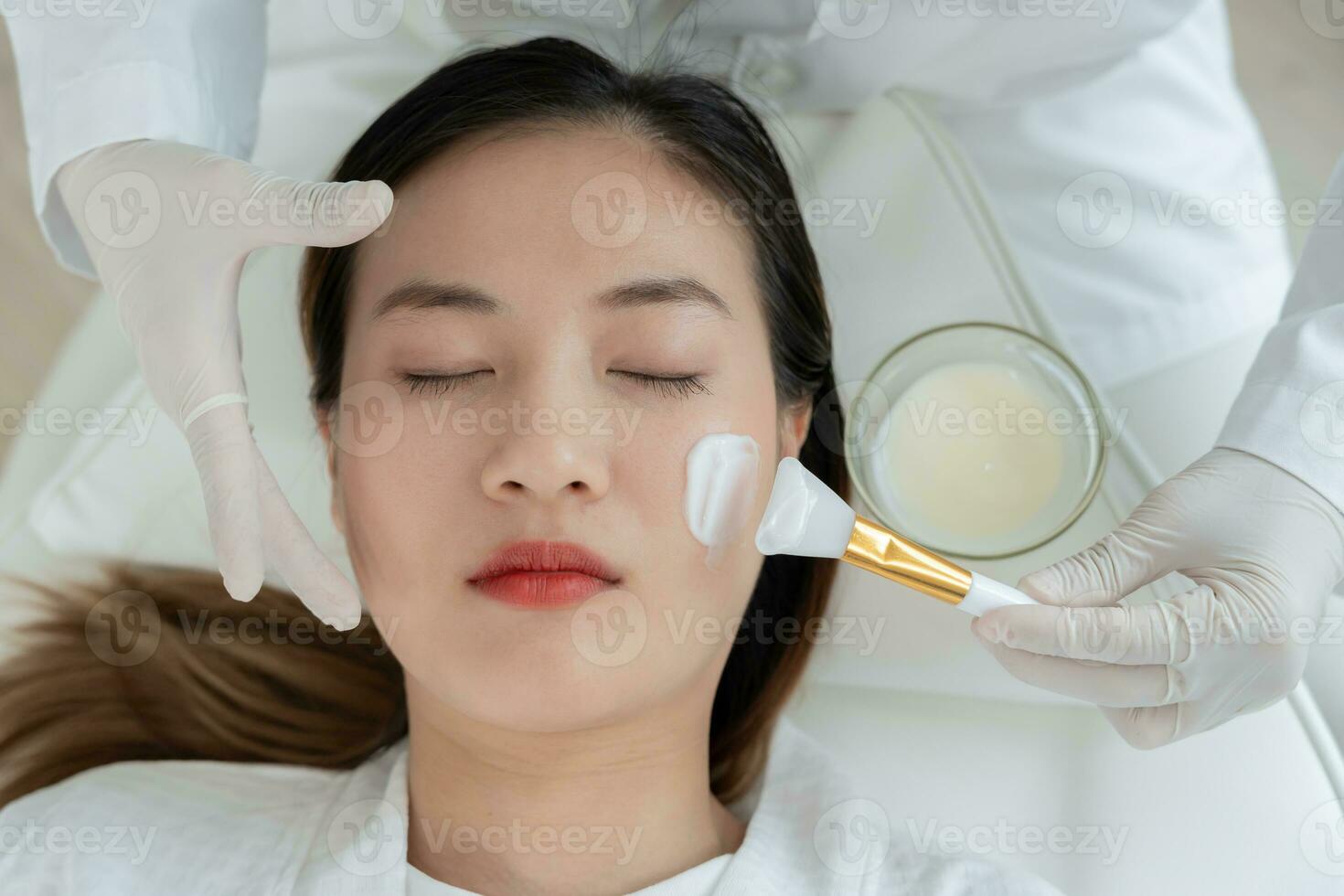 magnifique femme recevoir spa et traitement peau de affronter. visage de une en bonne santé femme appliquer crème. publicité pour peau crème, anti-rides, bébé affronter, blanchiment, Crème hydratante, serrer les pores sérum photo