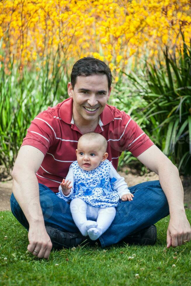 Jeune père ayant amusement en plein air avec le sien six mois vieux bébé fille. bonheur concept. famille concept photo