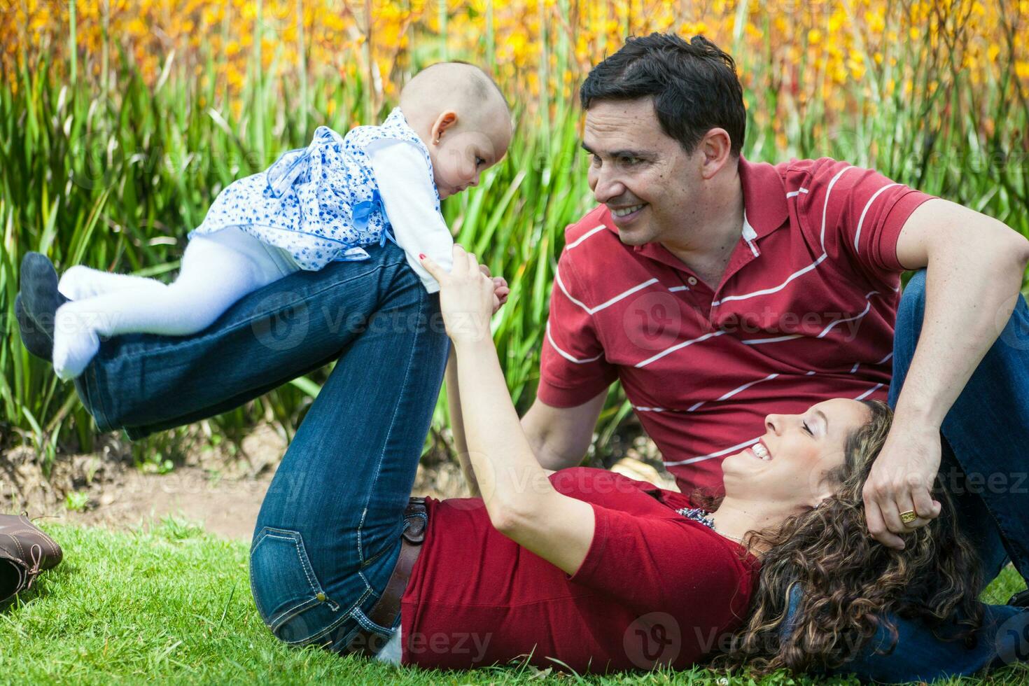 Jeune Parents ayant amusement en plein air avec leur six mois vieux bébé fille. bonheur concept. famille concept photo