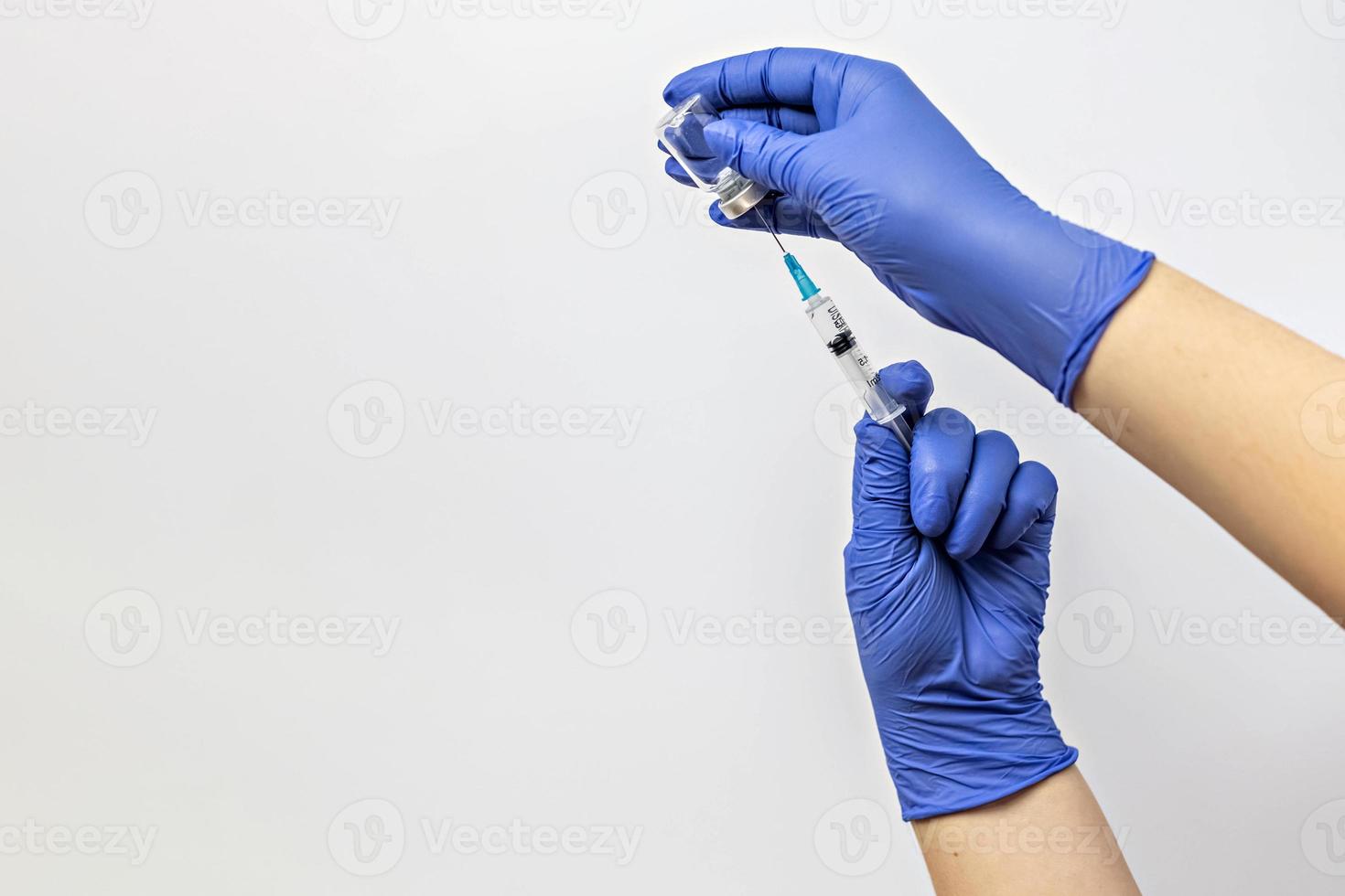 un travailleur médical dans des gants médicaux aspire une dose de vaccin contre le coronavirus dans une seringue photo