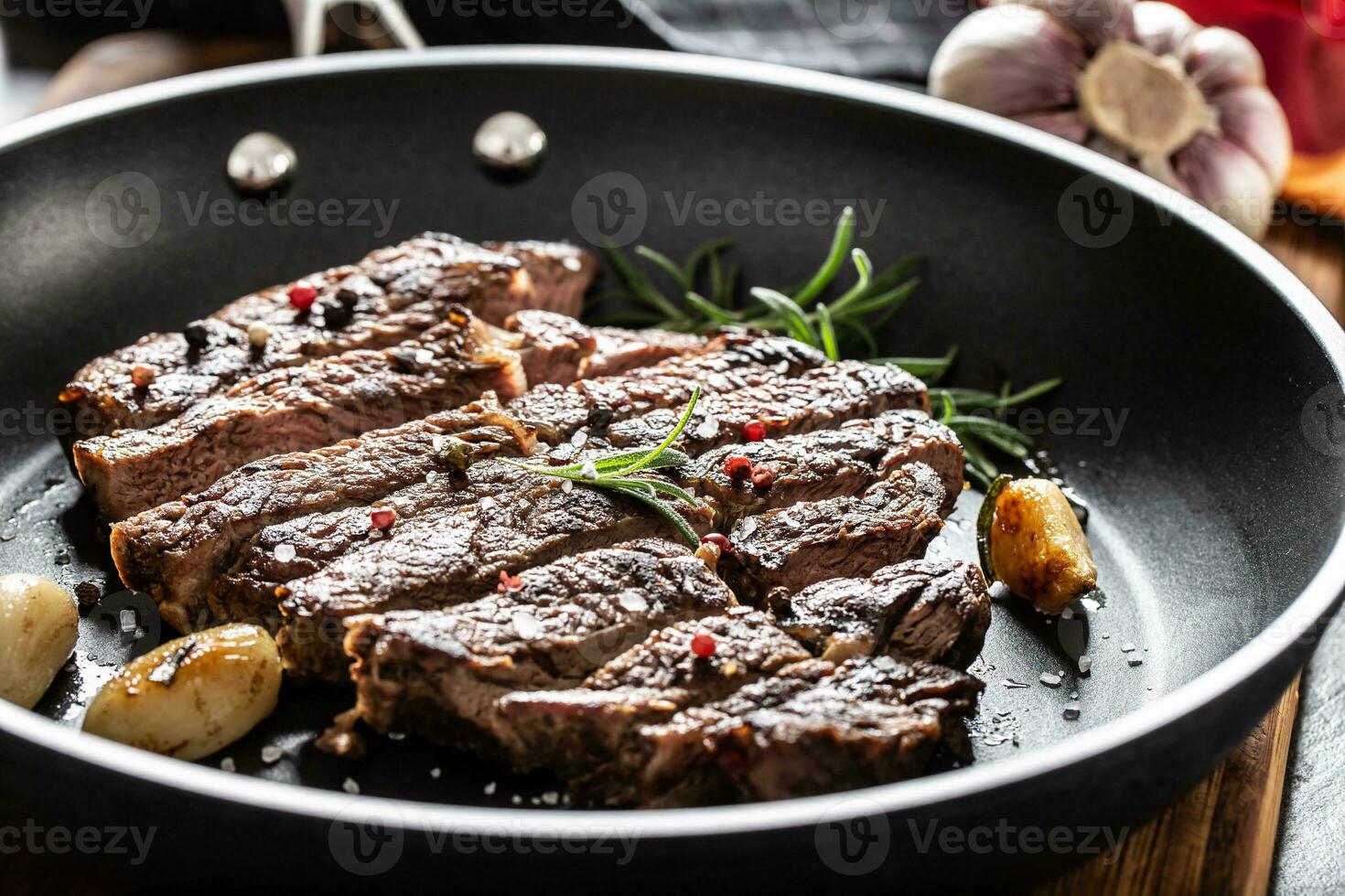 juteux et grillé du boeuf nervure œil steak dans téflon la poêle avec sel, poivre et Romarin herbes photo