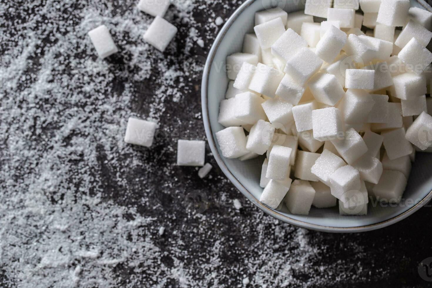 blanc sucre cubes dans une bleu bol sur le table photo