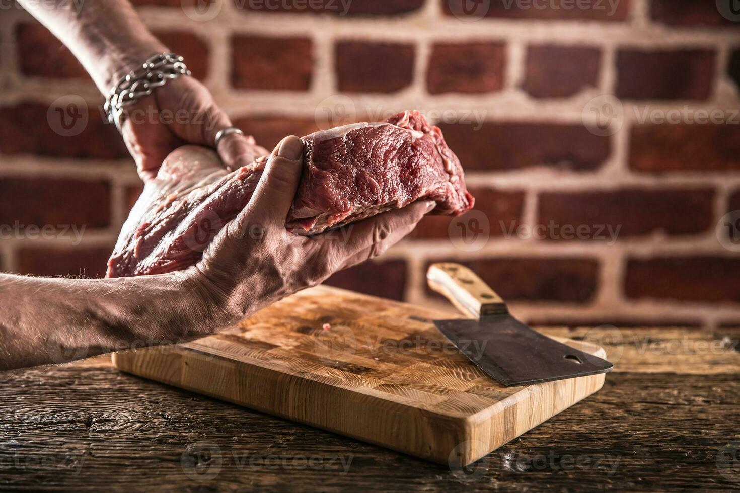 Boucher homme mains en portant brut du boeuf steak dans boucherie. photo