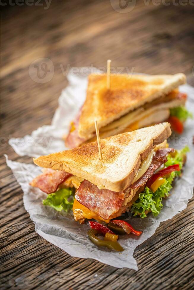 club sandwich sur une rustique table sorcière poulet, bacon, poivre et salade. photo