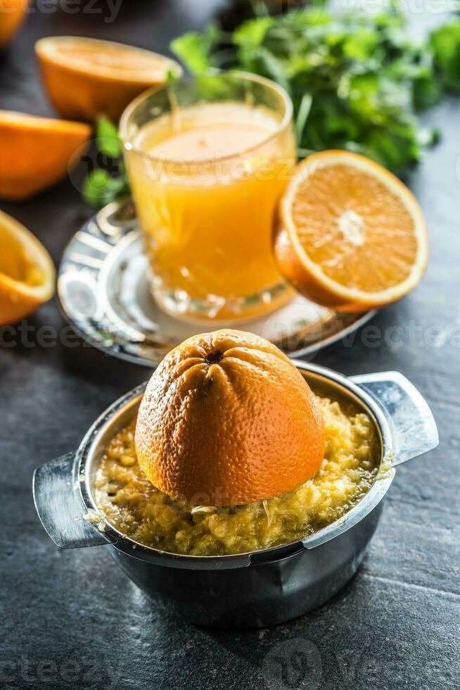 Frais des oranges presse-agrumes jus tropical des fruits et herbes sur béton planche photo