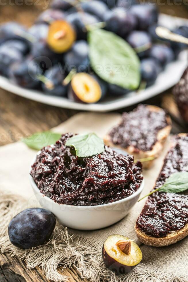 petit déjeuner de fait maison prune confiture pain et mûr prunes. photo