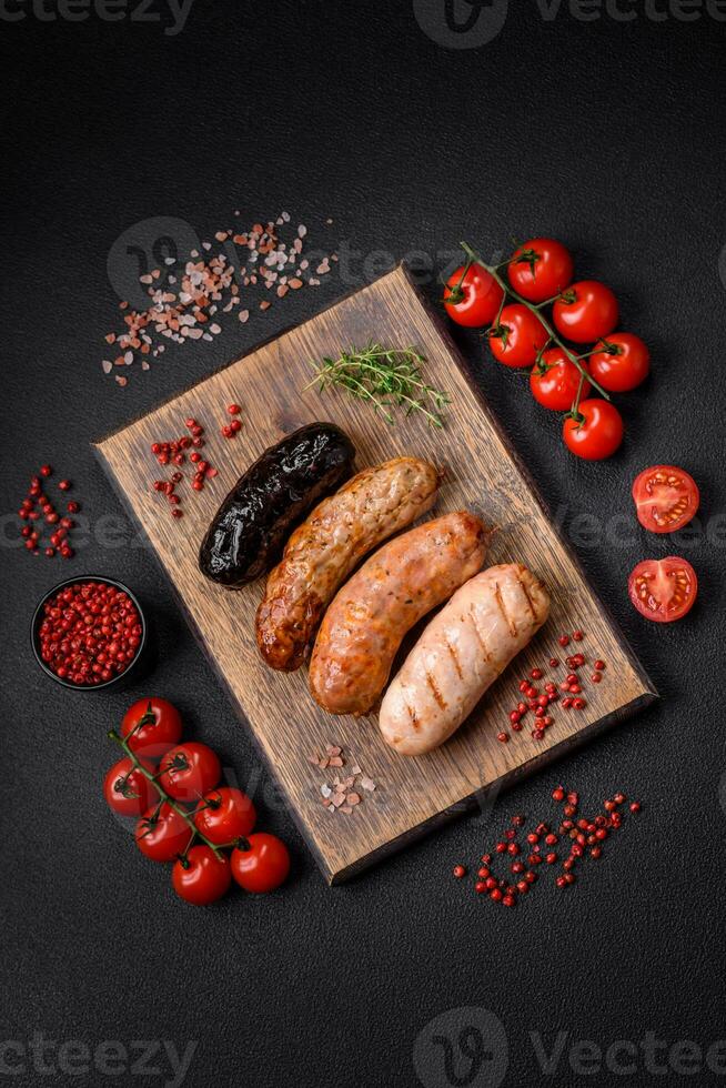 délicieux juteux saucisses de nombreuses variétés grillé avec sel, épices et herbes photo