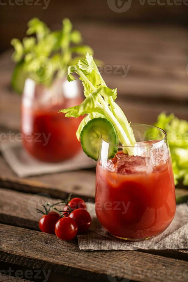 sanglant ou vierge Marie cocktail servi dans une tasse avec céleri des bâtons et Cerise tomates photo